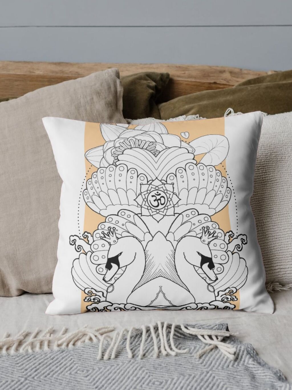 An image of a couch with throw pillows. The showcased has a Swan Mandala design on it, made with LinTu.studio clipart.